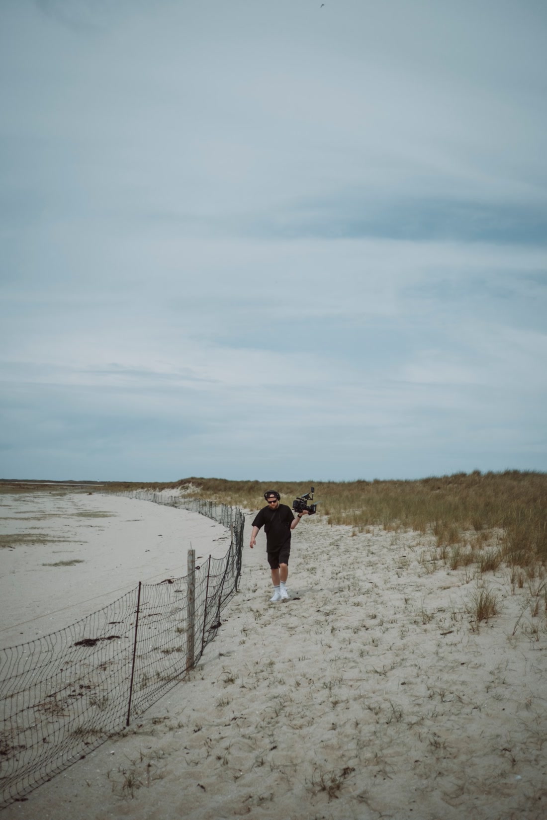 Leon Saß läuft mit seiner Kamera über den Strand an der Nordsee